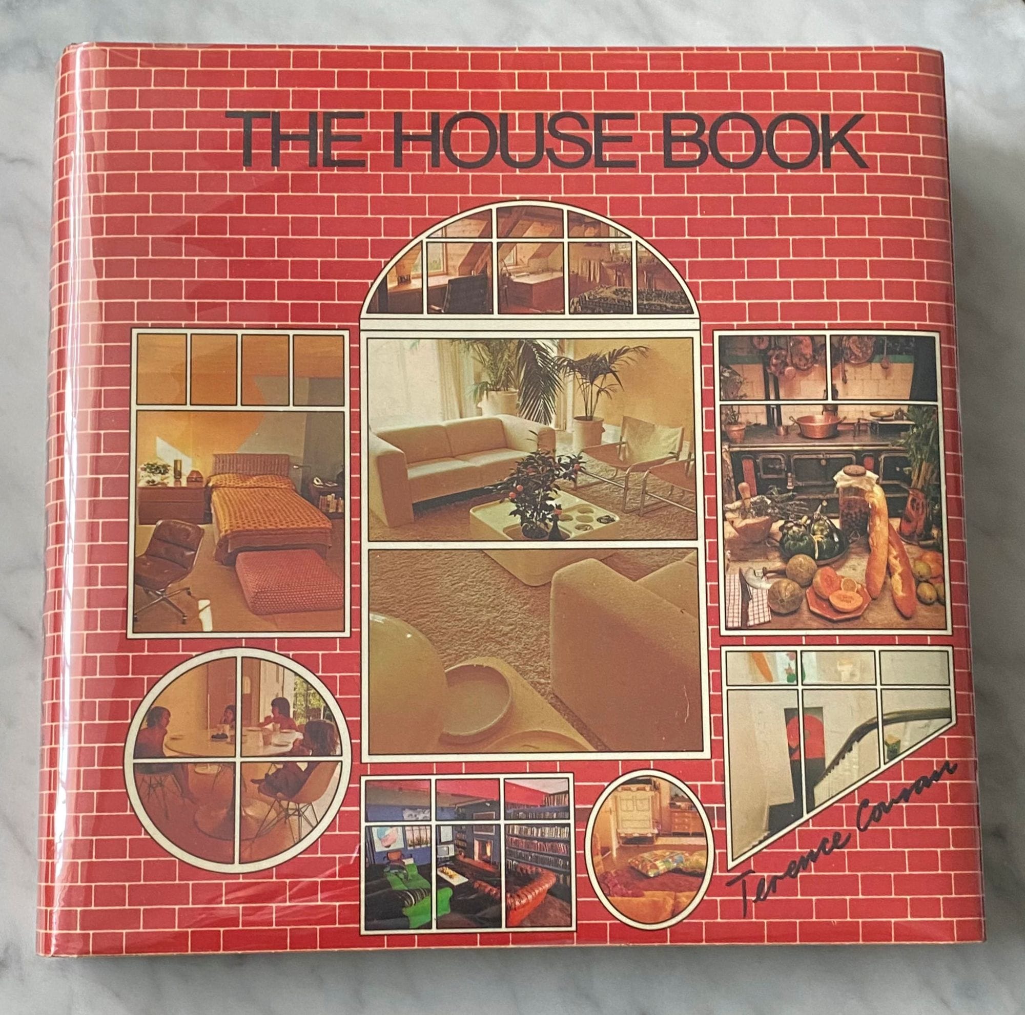 "The House Book" displayed on a light grey marble tabletop.