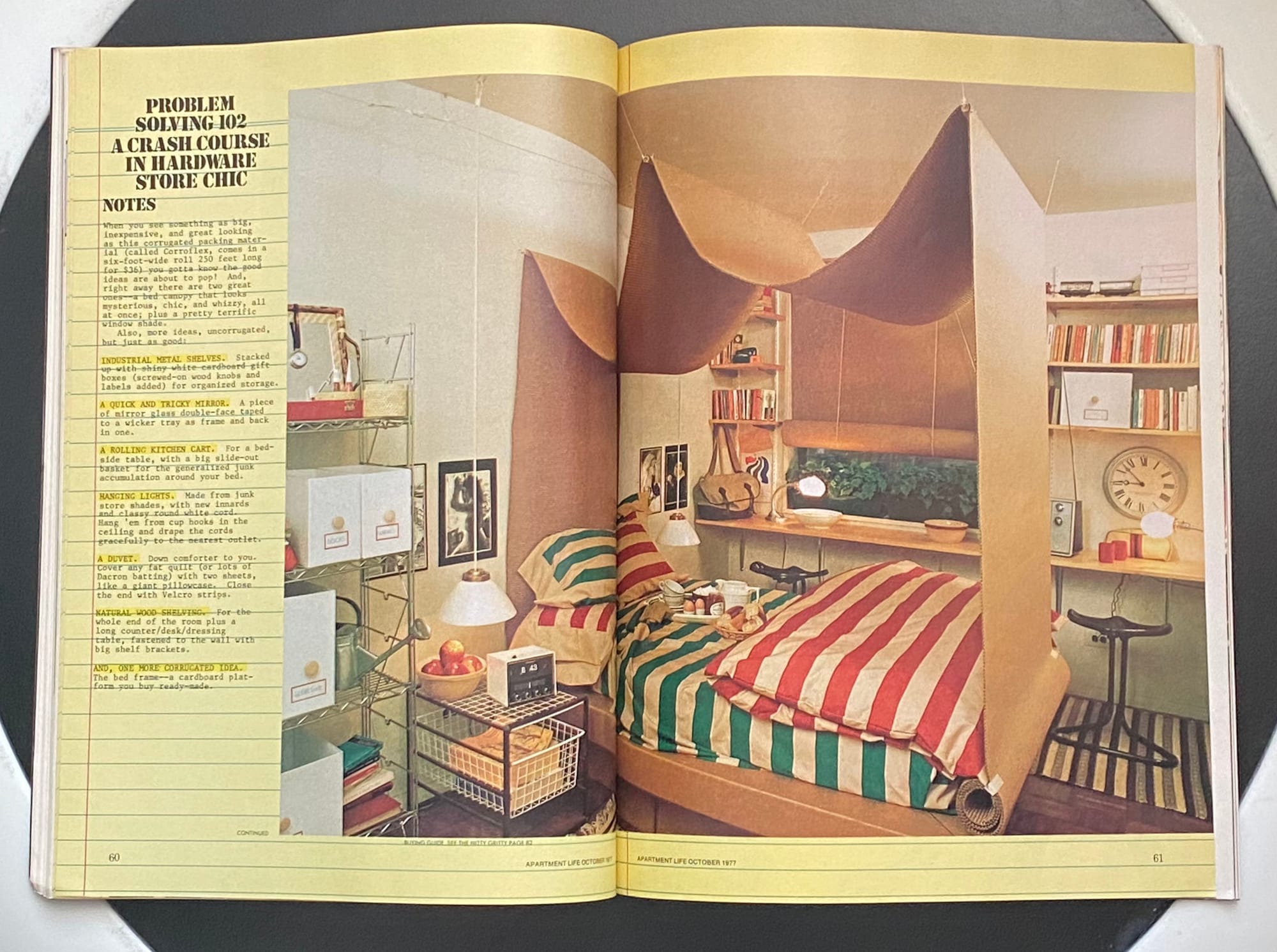 A bed with striped bed linens and a corrugated cardboard canopy.
