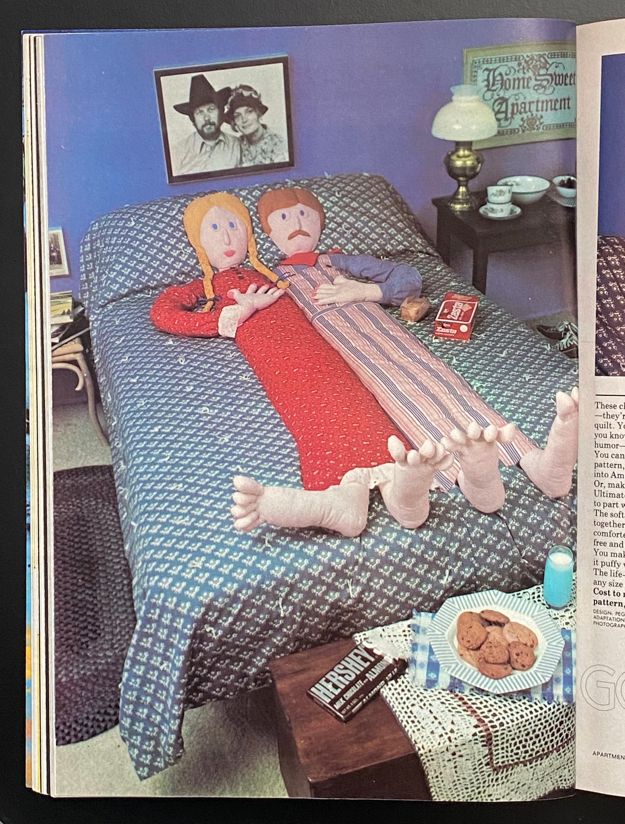 A soft-sculpture man and woman embedded in a bedspread.