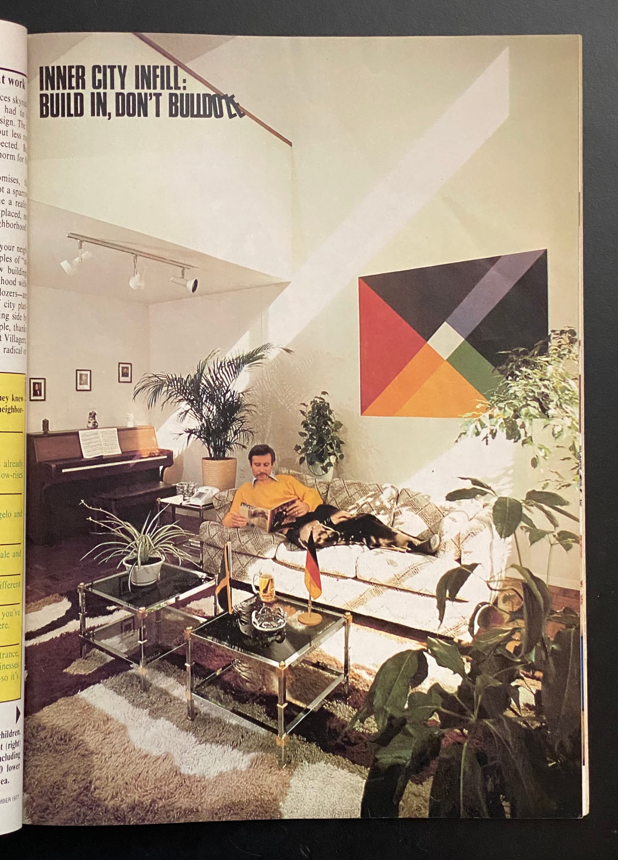 A man lounges on a sofa reading a magazine in a super-stylish living room.