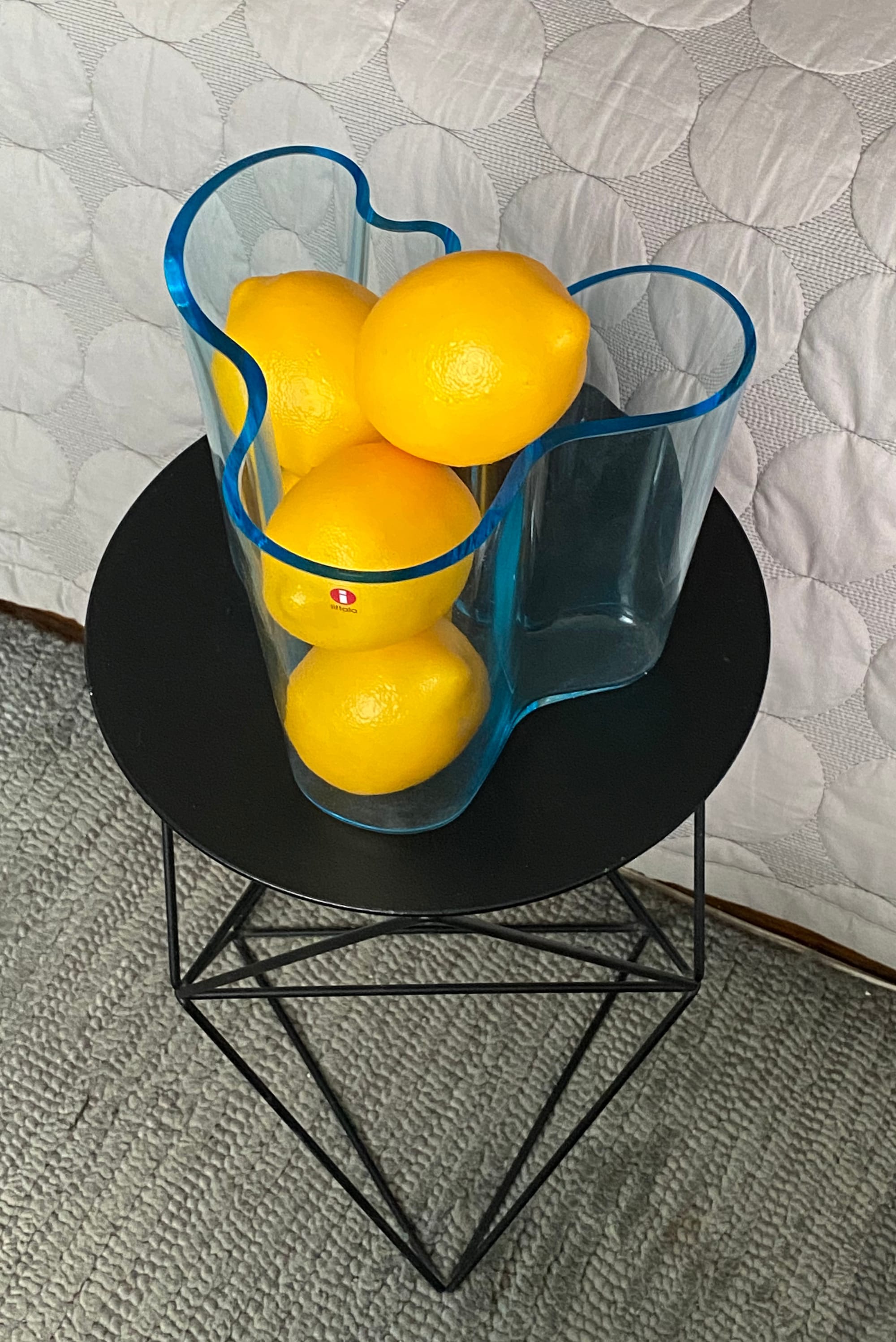 Blue Savoy vase containing five lemons, with a small red Iitala label at the front.